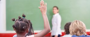 child raising hand in class