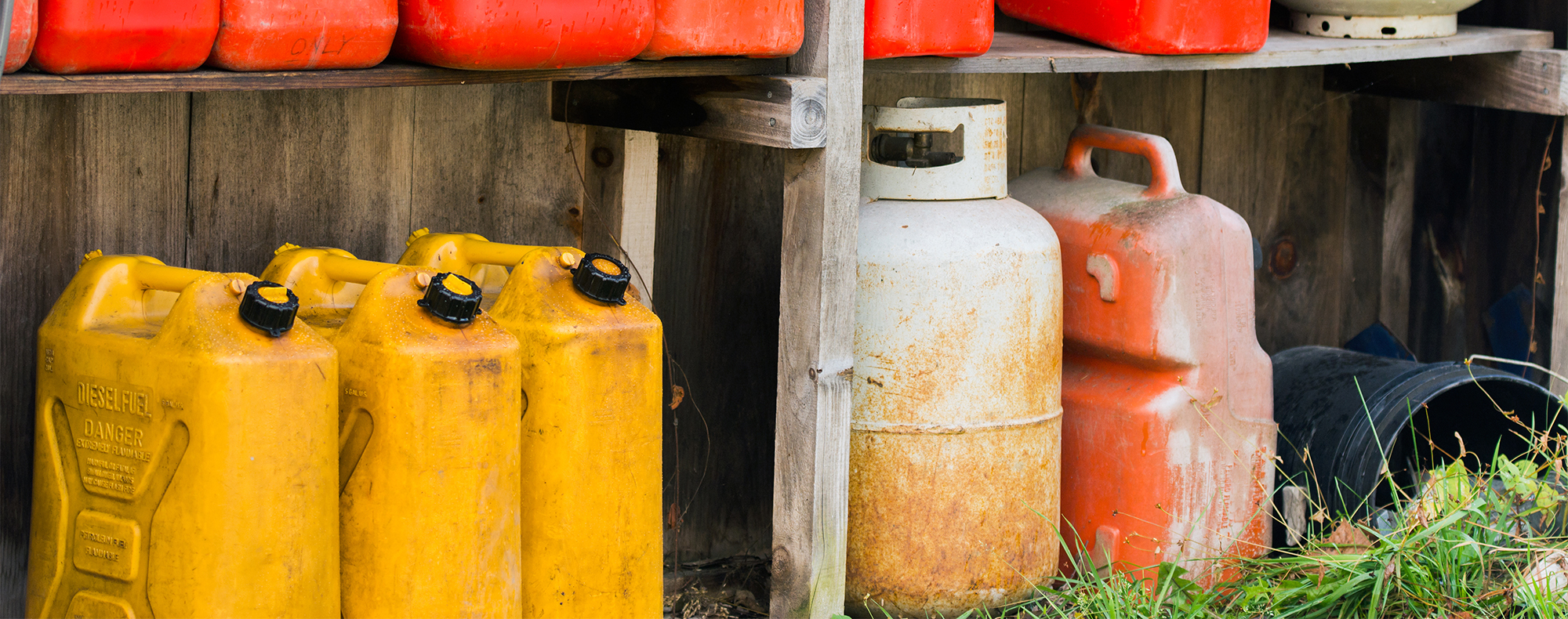 Gasoline, propane, and diesel containers on shelf